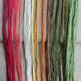 Set of colorful embroidery threads on a textured fabric background