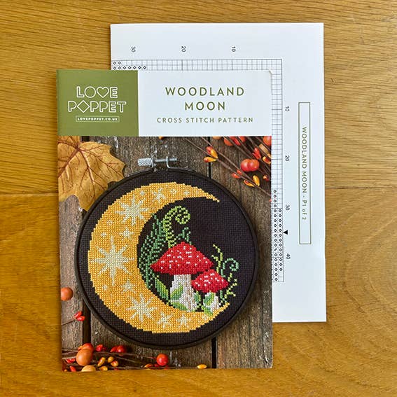 Cross stitch kit with 'Woodland Moon' design on a wooden surface