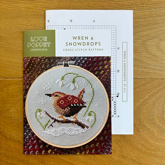 Cross stitch kit with a wren design on a wooden surface