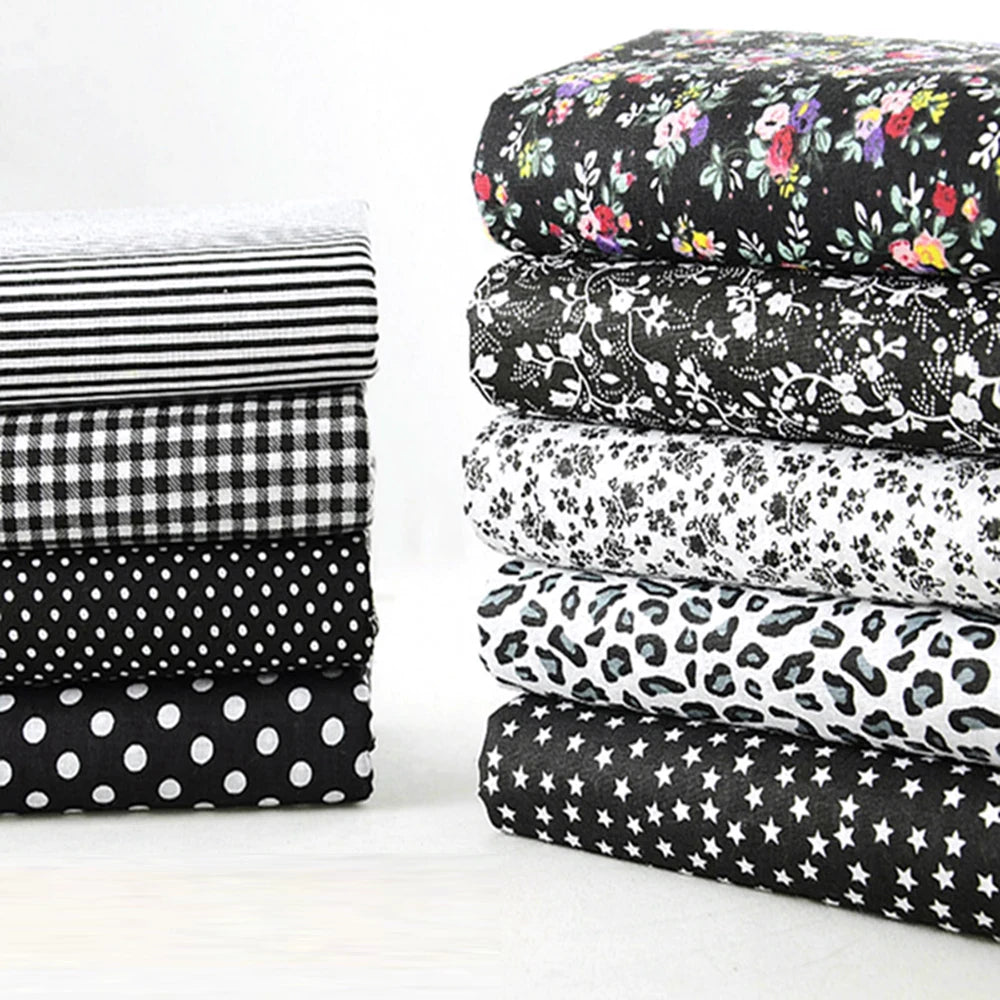 Stack of black and white patterned fabrics on a white background
