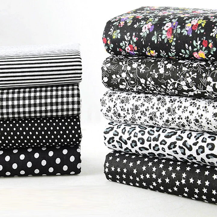 Stack of black and white patterned fabrics on a white background
