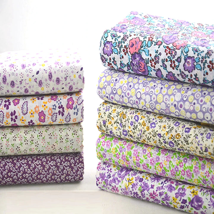 Stack of floral fabric sheets with various patterns on a white background