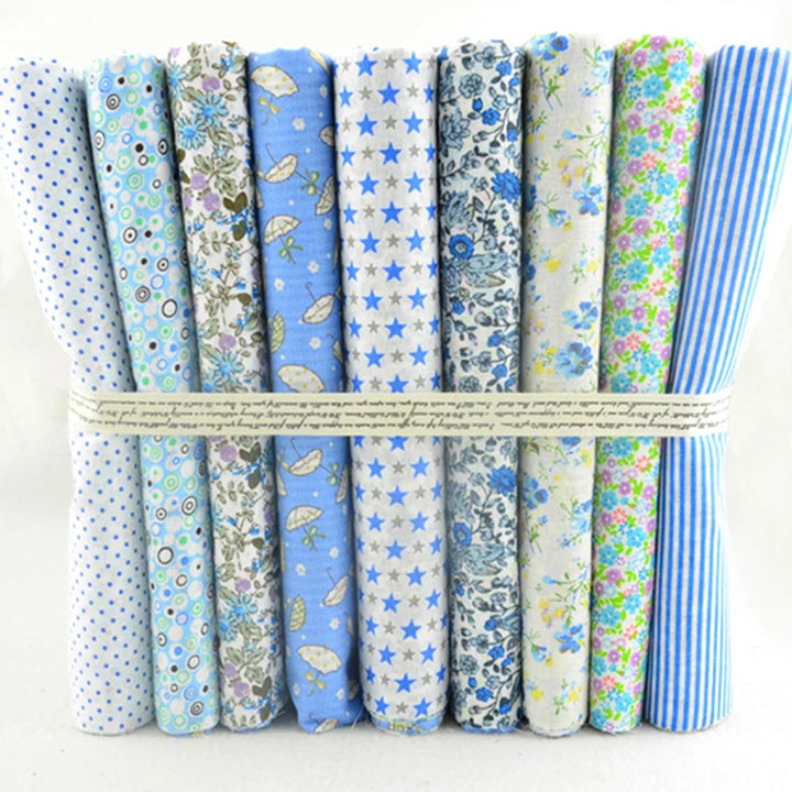 Set of fabric rolls with various patterns tied together on a white background