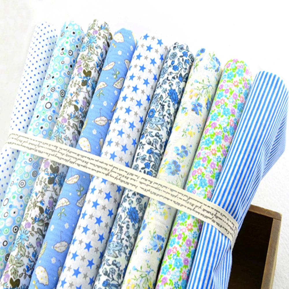 Collection of fabric rolls with various patterns tied together on a white background