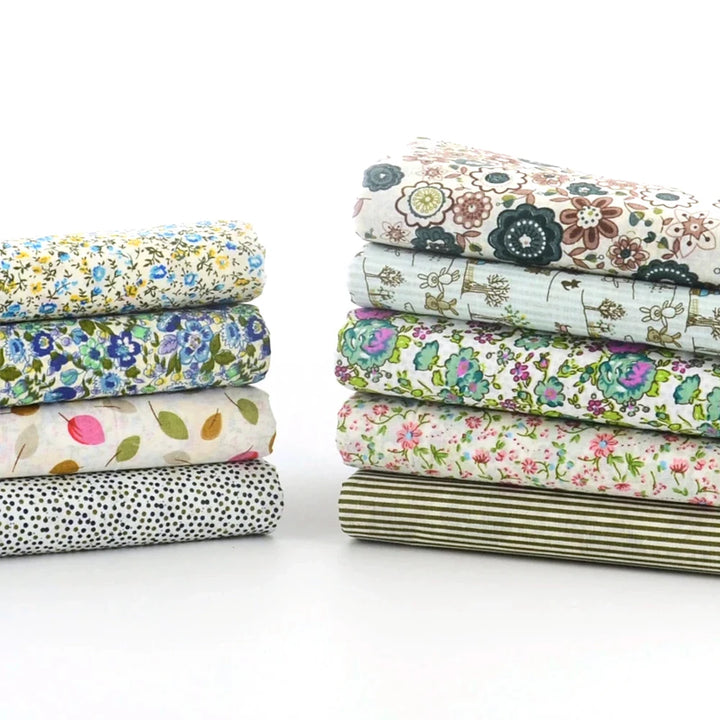 Stack of floral and patterned fabric sheets on a white background