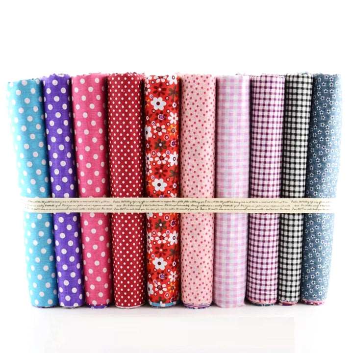 Set of colorful fabric rolls with various patterns tied together on a white background