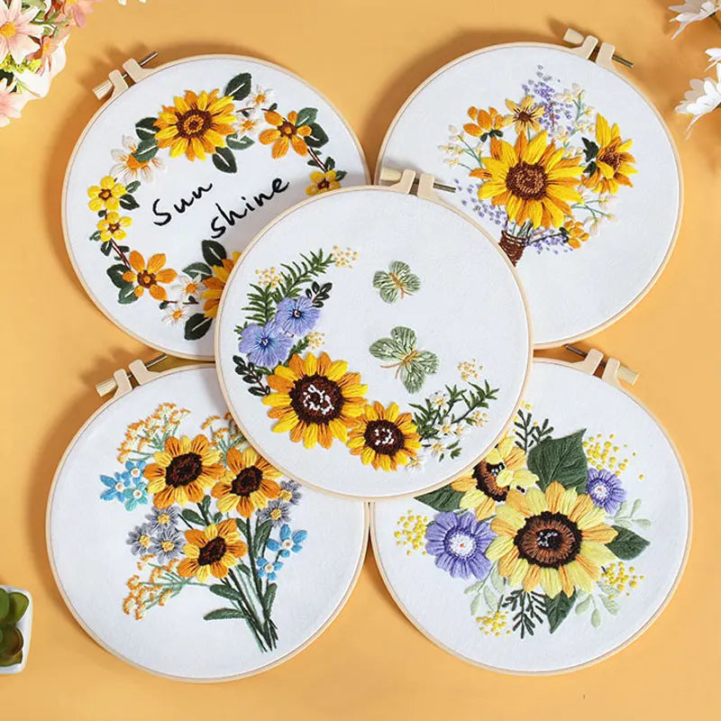 Set of embroidered hoops with sunflower designs on a yellow background