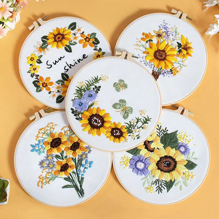 Set of embroidered hoops with sunflower designs on a yellow background