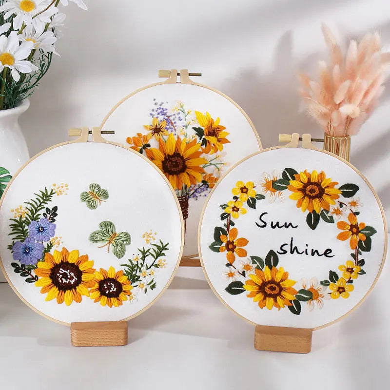 Three embroidery hoops with floral designs and 'Sunshine' text on a white background.
