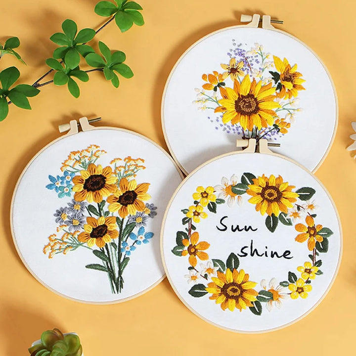 Three embroidery hoops with floral designs on a yellow background