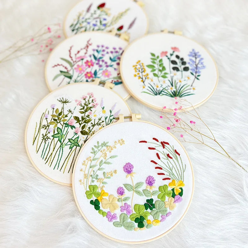 Set of embroidered floral designs in gold hoops on a soft white background