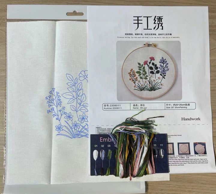 Embroidery kit with fabric, thread, and instructions on a wooden surface