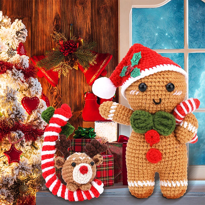 Crocheted gingerbread man toy with candy cane and reindeer in a festive setting.