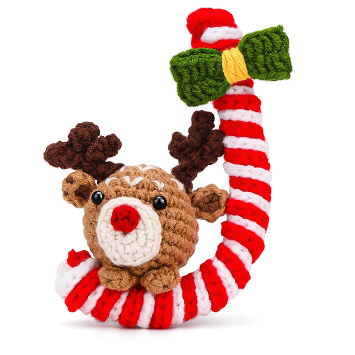 Crocheted reindeer toy with candy cane and mistletoe on a white background