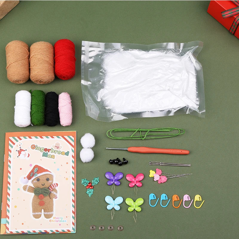 Crafting supplies including yarn, plastic bags, a card, and decorative items on a green surface.