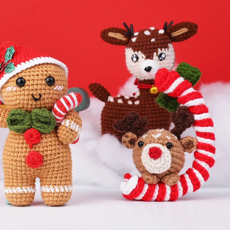 Three crocheted Christmas-themed toys including a gingerbread man, reindeer, and candy cane on a red background.
