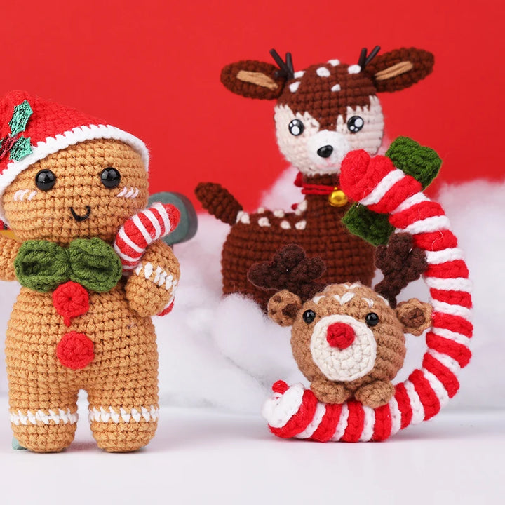 Three crocheted Christmas-themed toys including a gingerbread man, reindeer, and candy cane on a red background.