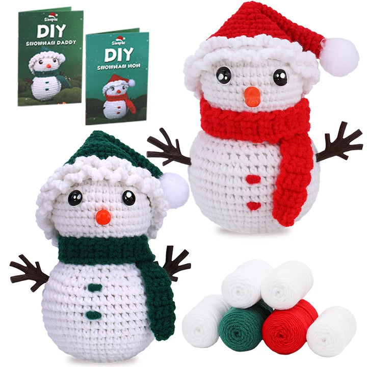 Two crocheted snowmen with accessories and a pattern book on a white background