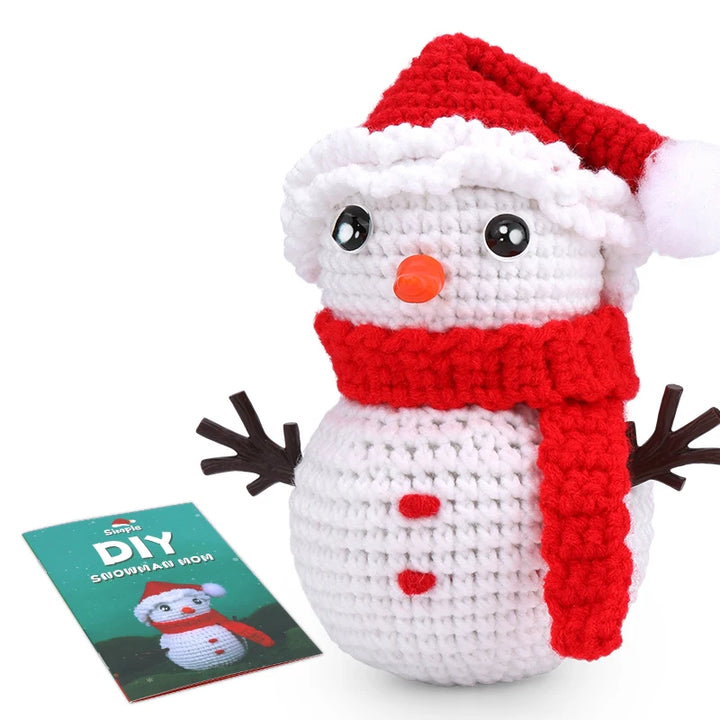 Crocheted snowman toy with a red scarf and hat, next to a DIY snowman kit on a white background.
