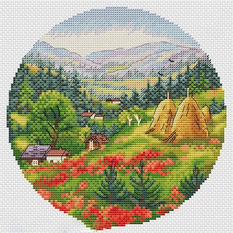 Cross-stitched landscape with greenery, houses, and mountains on a white background