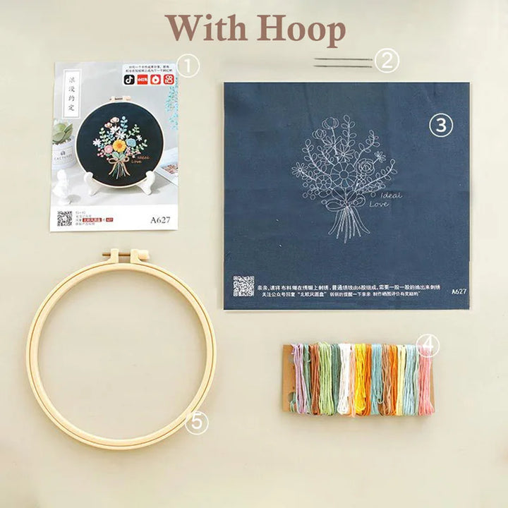 Embroidery hoop with thread and pattern book on a beige background