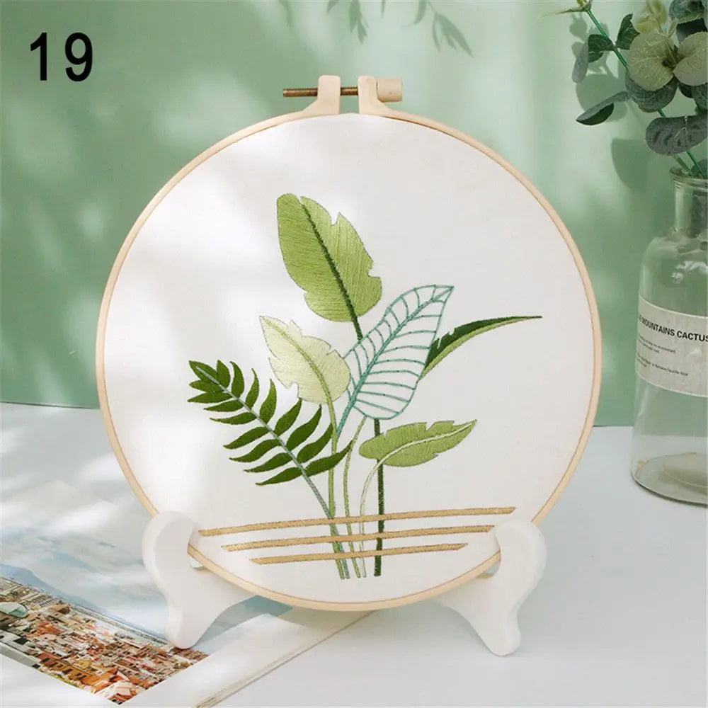 Embroidery hoop with green leaf design on a white background