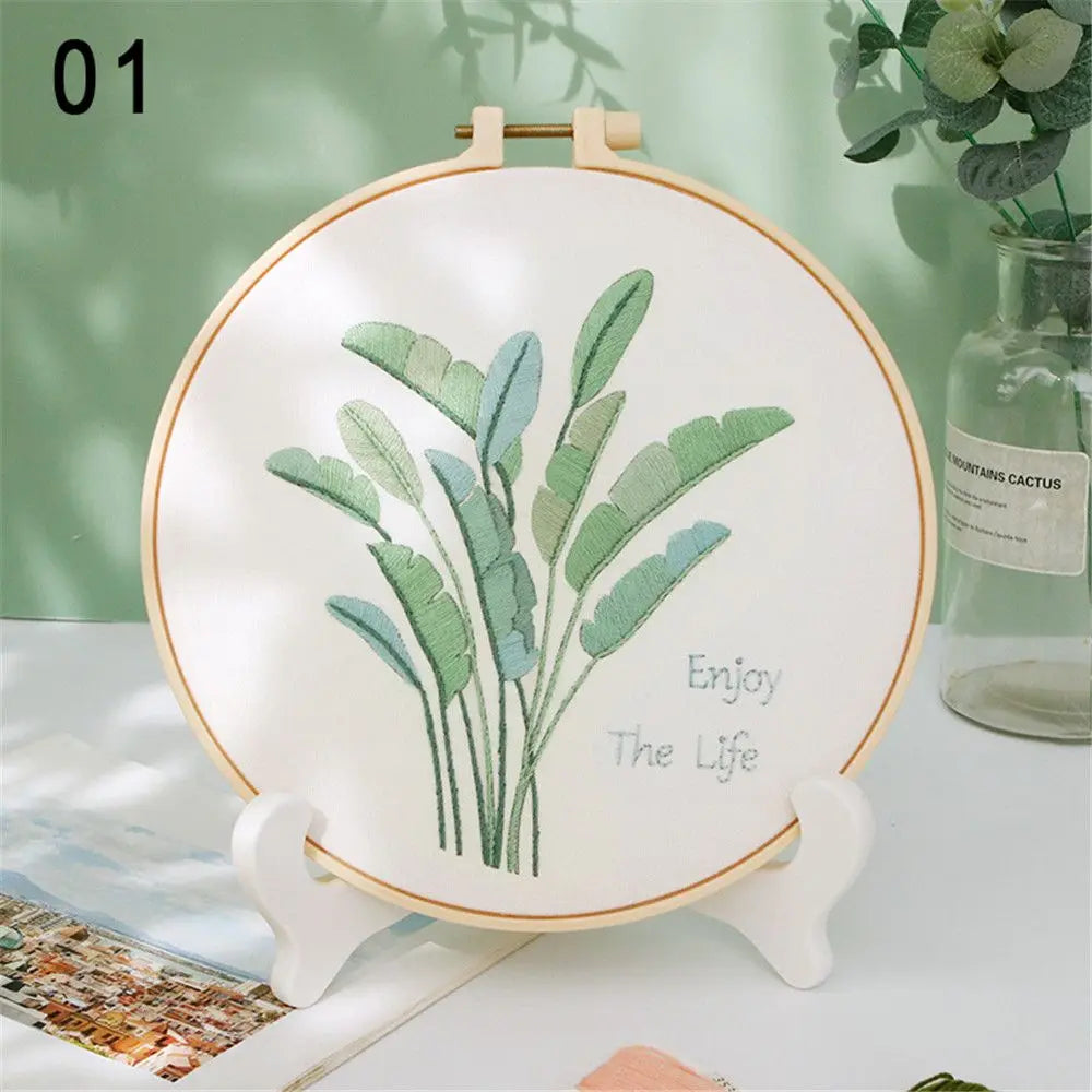 Embroidery hoop with green leaf design and 'Enjoy The Life' text on a light background