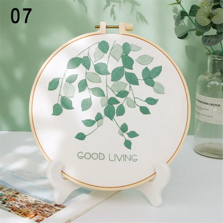 Decorative hoop with green leaf design and 'GOOD LIVING' text on a white surface.