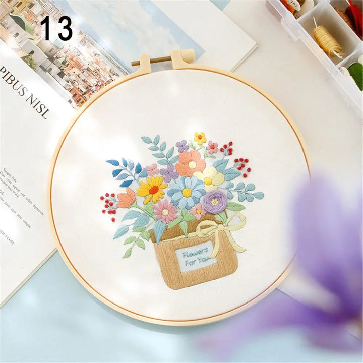 Embroidery hoop with a colorful floral design on a light blue surface.