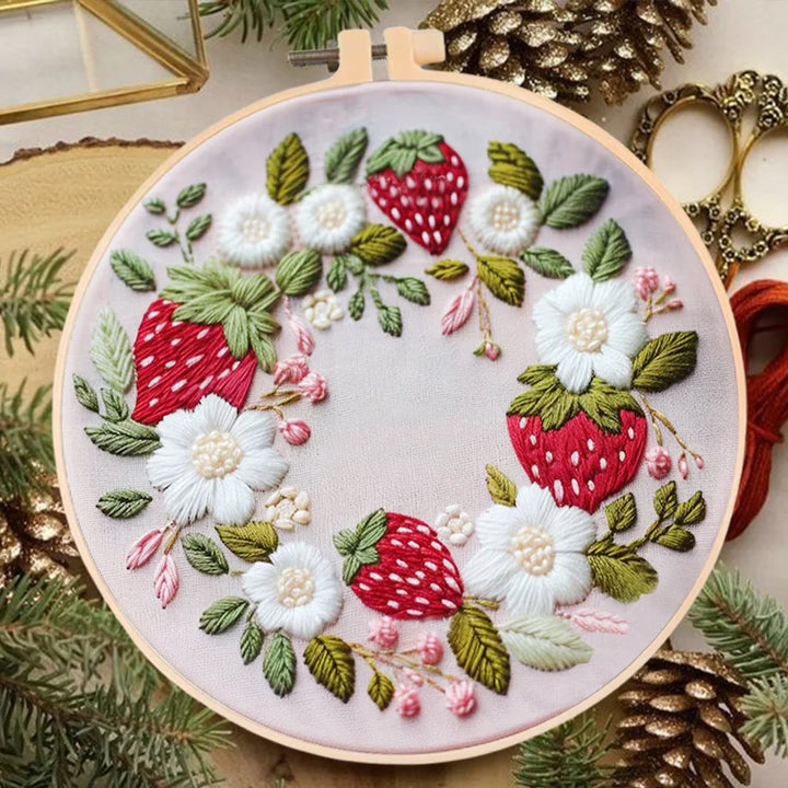 Embroidery hoop with strawberry and floral design on a decorative background