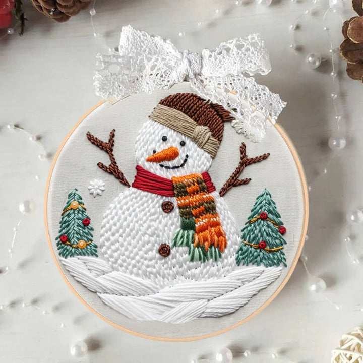 Embroidery hoop with a snowman design on a textured surface