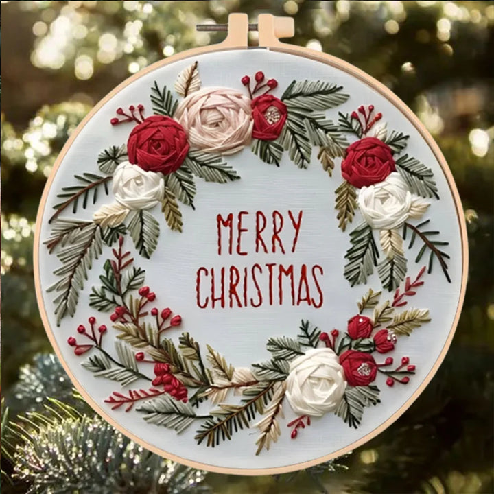Embroidery hoop with floral design and 'Merry Christmas' text on a blurred Christmas tree background.