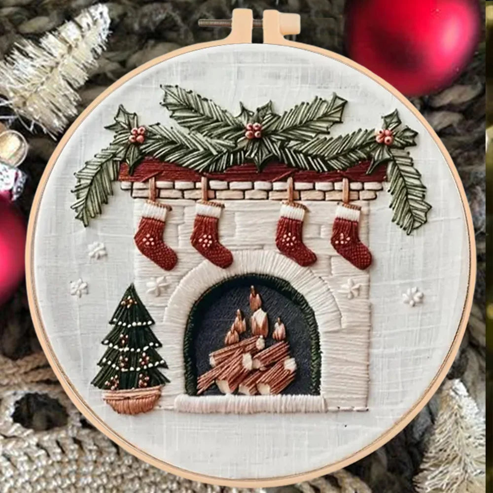 Embroidery hoop with a festive design of stockings, a fireplace, and Christmas tree.