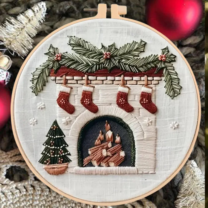 Embroidery hoop with a festive design of stockings, a fireplace, and Christmas tree.