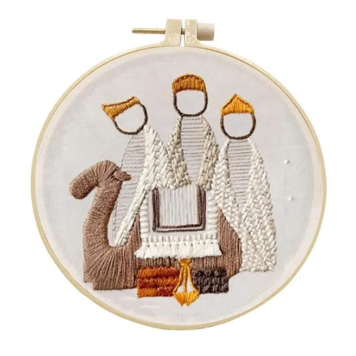 Embroidery hoop with a religious scene featuring three figures and a camel on a white background