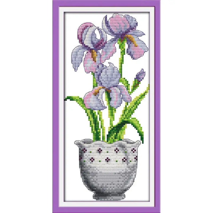 Cross-stitched design of purple flowers in a pot with a purple frame.