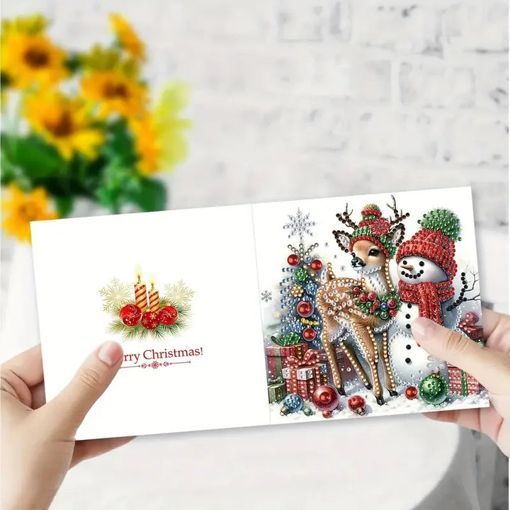 Christmas card with a deer, snowman, and Christmas tree held by hands against a light gray background.