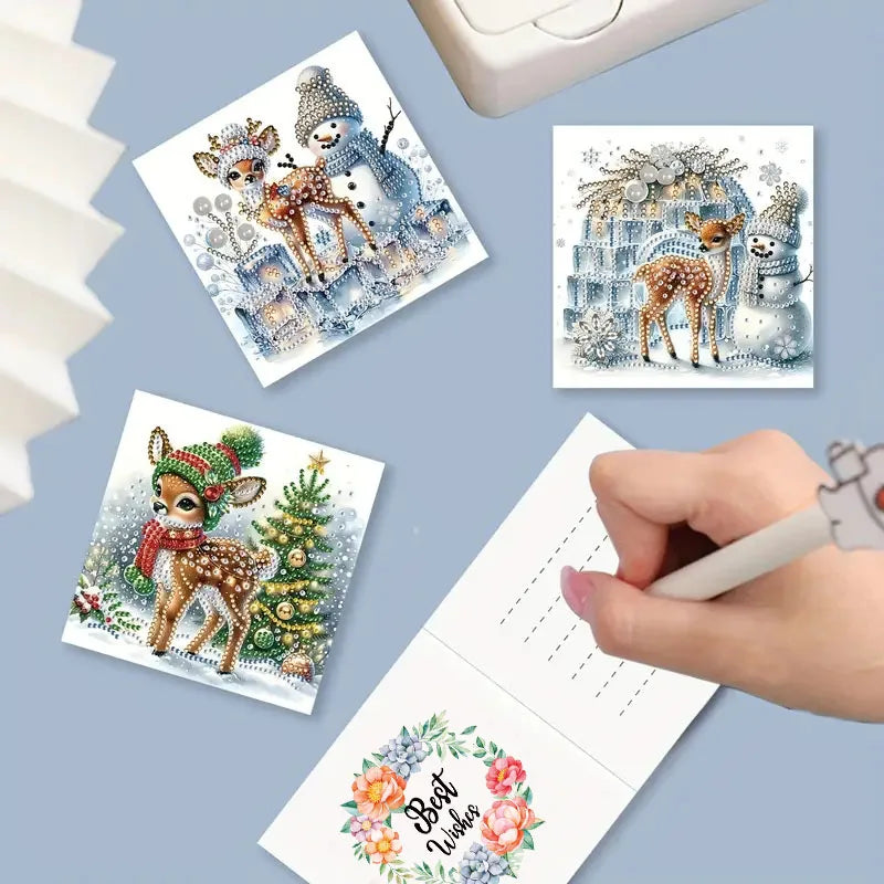 Set of diamond painting cards with Christmas-themed designs on a blue surface.