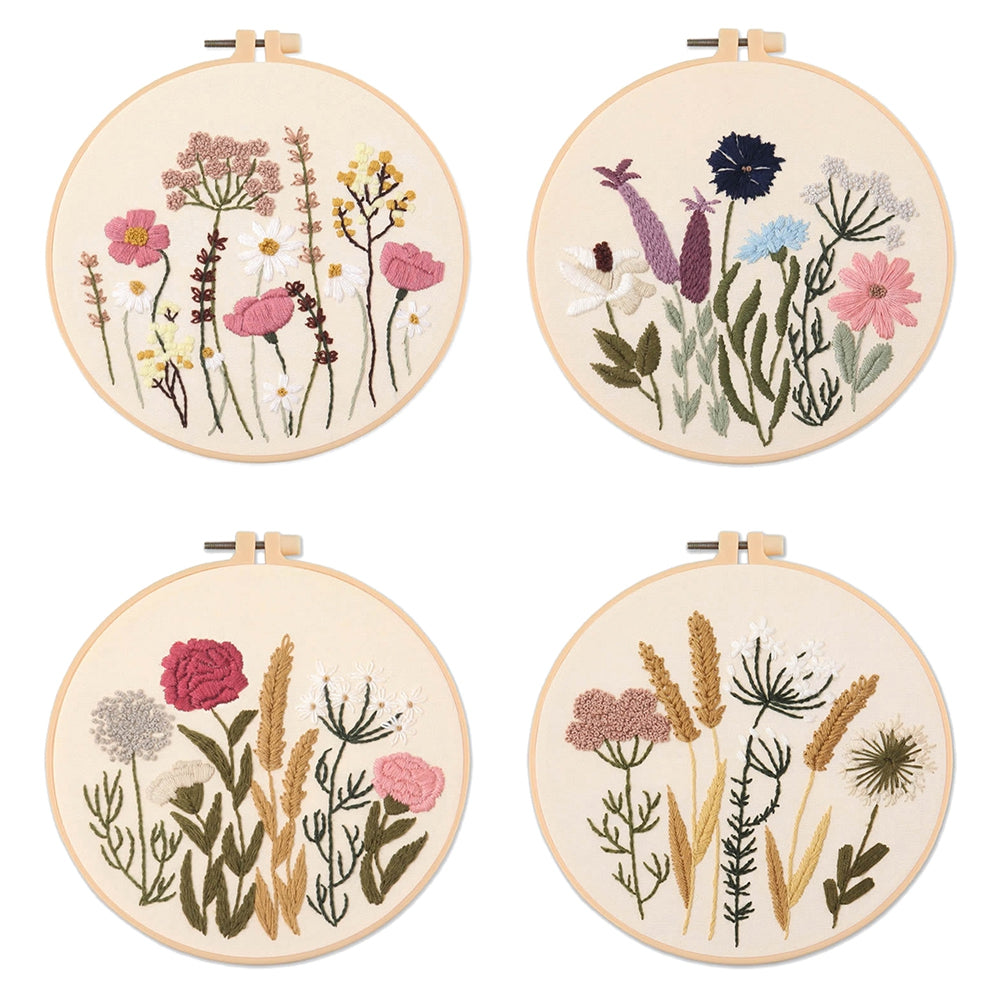 Four embroidered hoops with floral designs on a white background