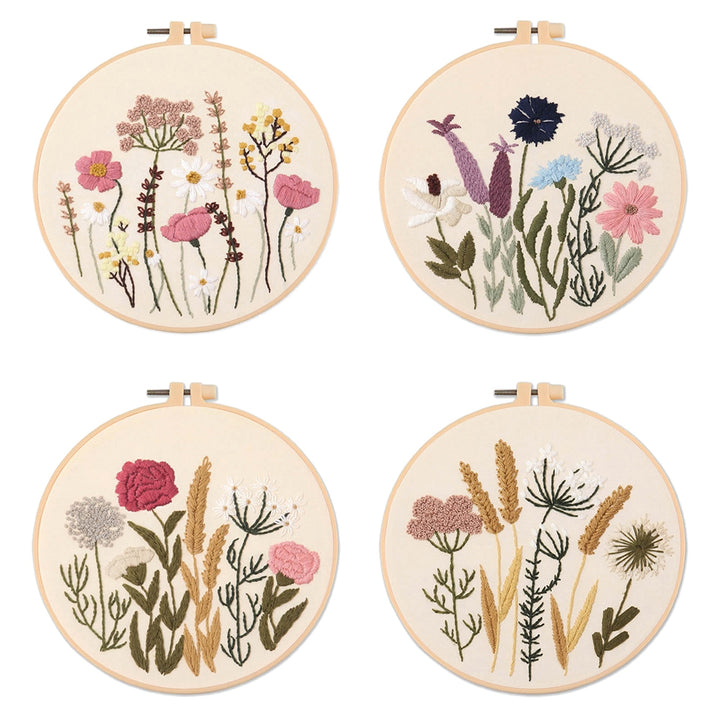 Four embroidered hoops with floral designs on a white background