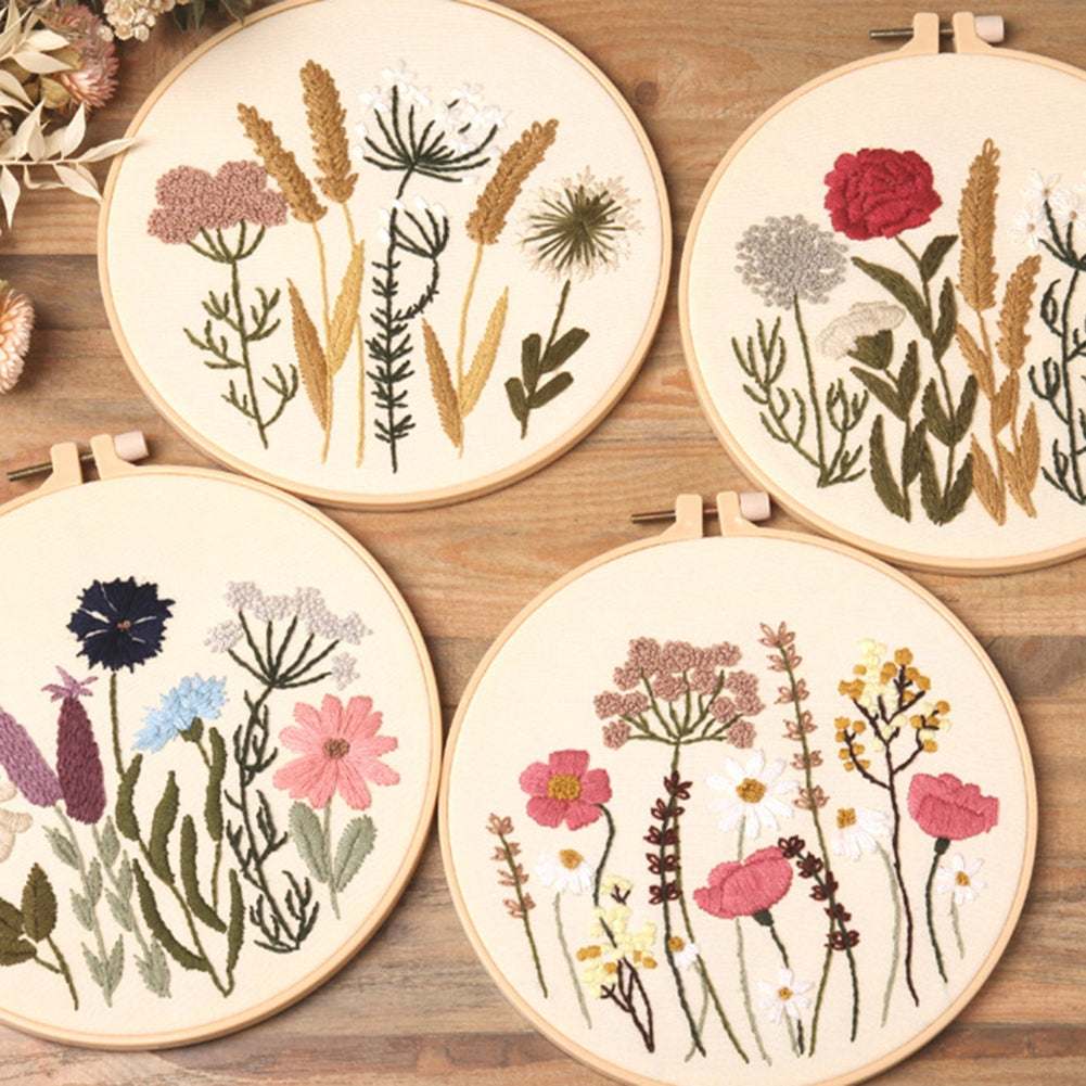 Four embroidery hoops with floral patterns on a wooden surface