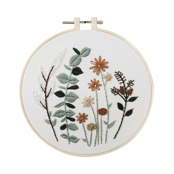 Embroidery hoop with floral and leaf design on a white background
