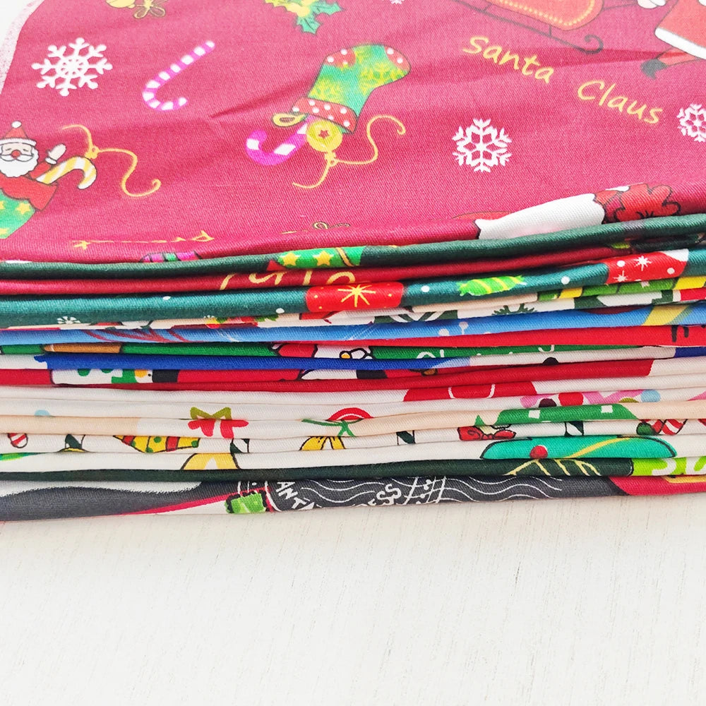 Stack of colorful fabric sheets with Christmas-themed designs on a white surface