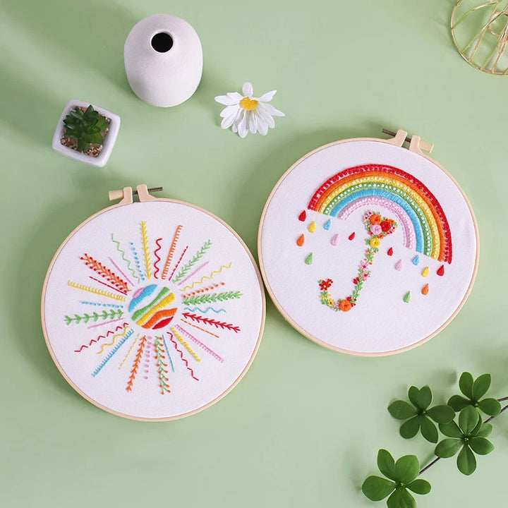 Two embroidery hoops with colorful designs on a green background