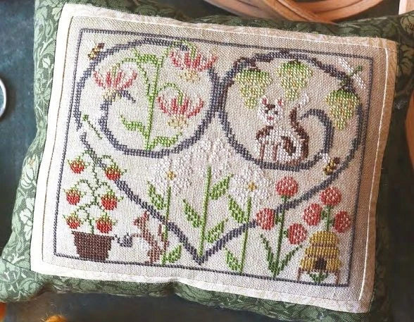 Embroidered panel with floral and animal designs on a green fabric background