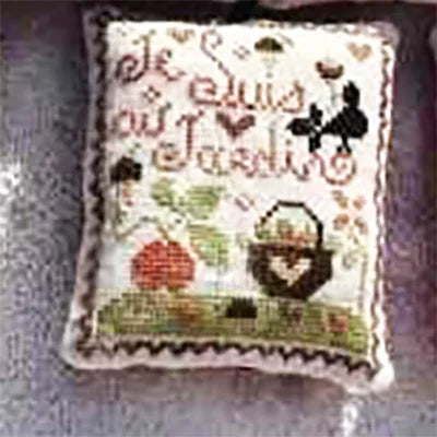 Cross-stitched pillow with decorative elements on a textured surface