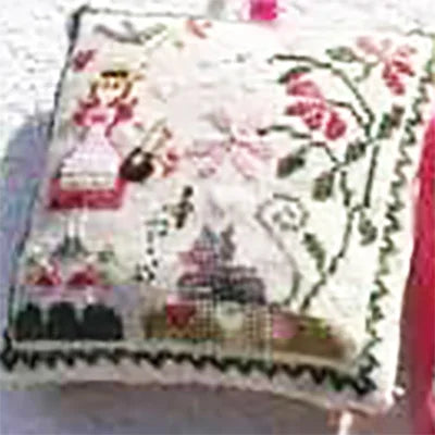 Decorative pillow with embroidered design of a ship and floral elements on a white background.