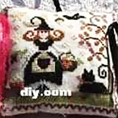 Decorative pillow with Halloween-themed design featuring a witch, pumpkins, and a cat.