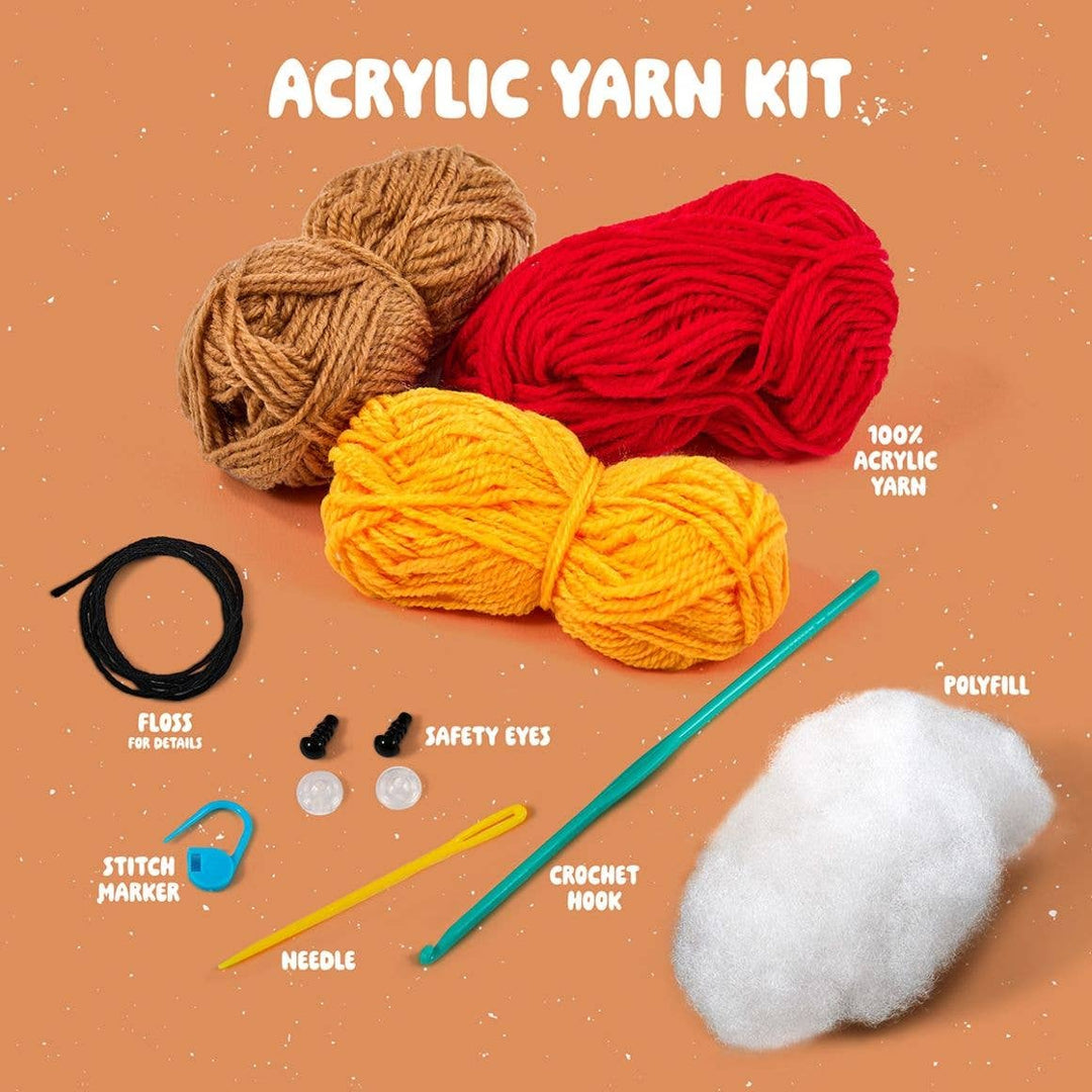 Acrylic yarn kit with yarn balls, crochet hook, safety eyes, and other tools on a brown background