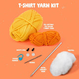 T-shirt yarn kit with yarn balls, safety eyes, needle, metal crochet hook, stitch marker, polyfill, and cotton on an orange background.